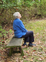 Woman sitting on bench in Folkways Model Woodland